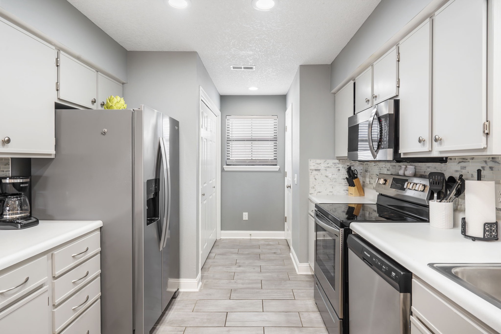 Unit 19: The sleek, updated kitchen is spacious & well-equipped for your visit