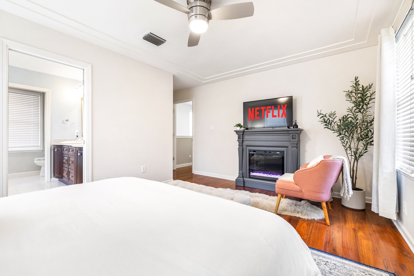 Bedroom 2 with king bed, TV, electric fireplace, and ensuite