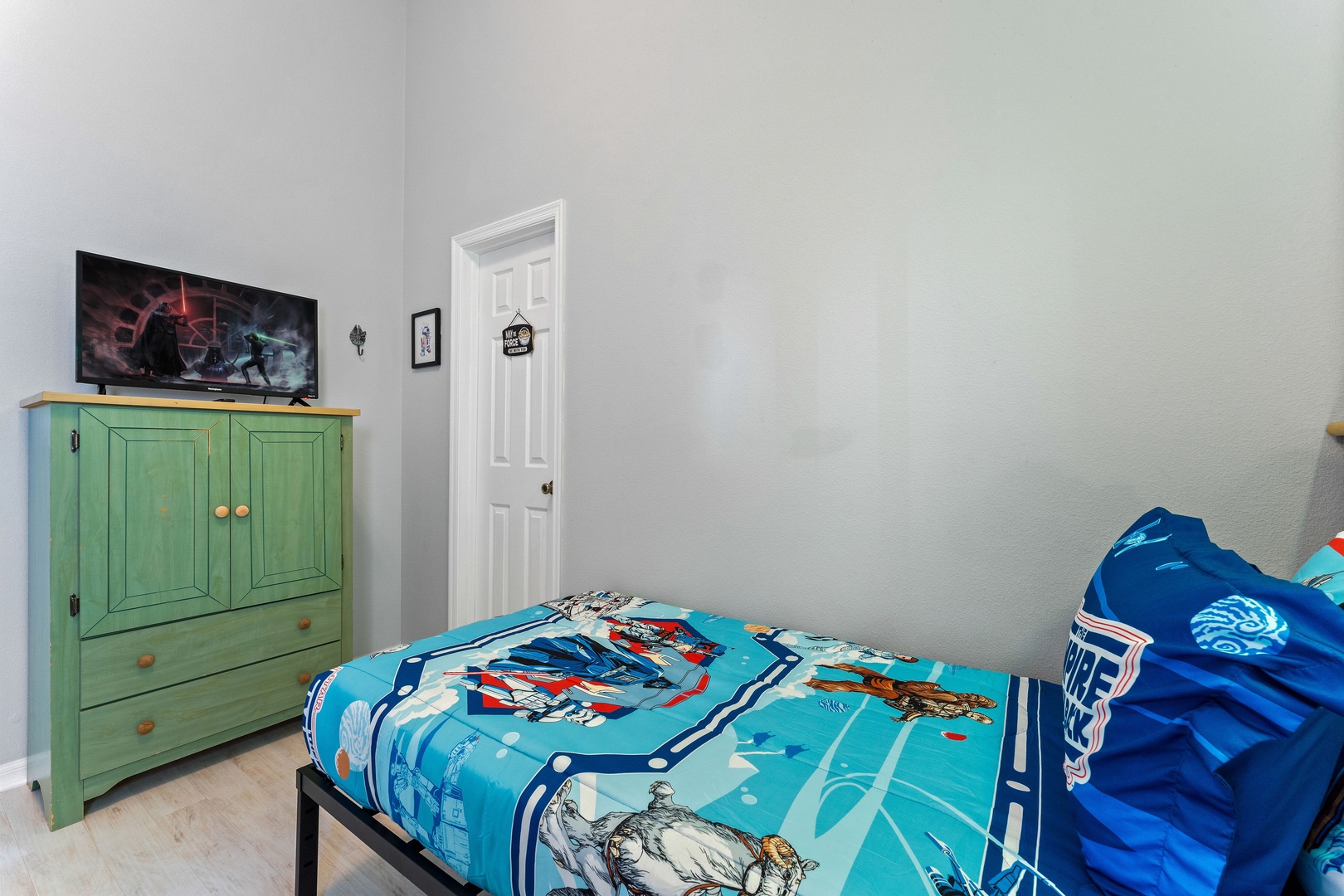 Galactic dreams await in this bedroom, offering two twin beds & a Smart TV