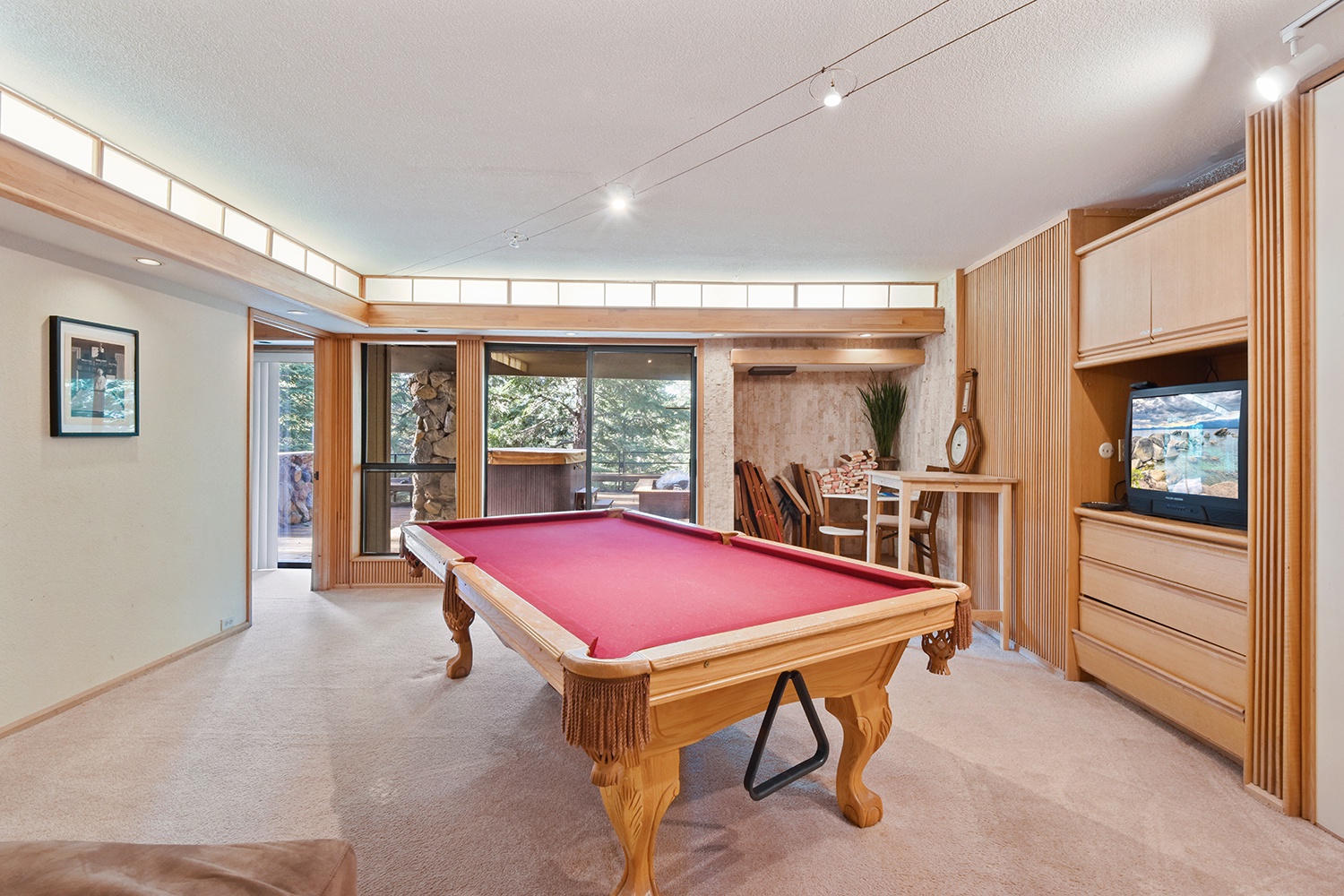 Ground level game room with pool table and TV