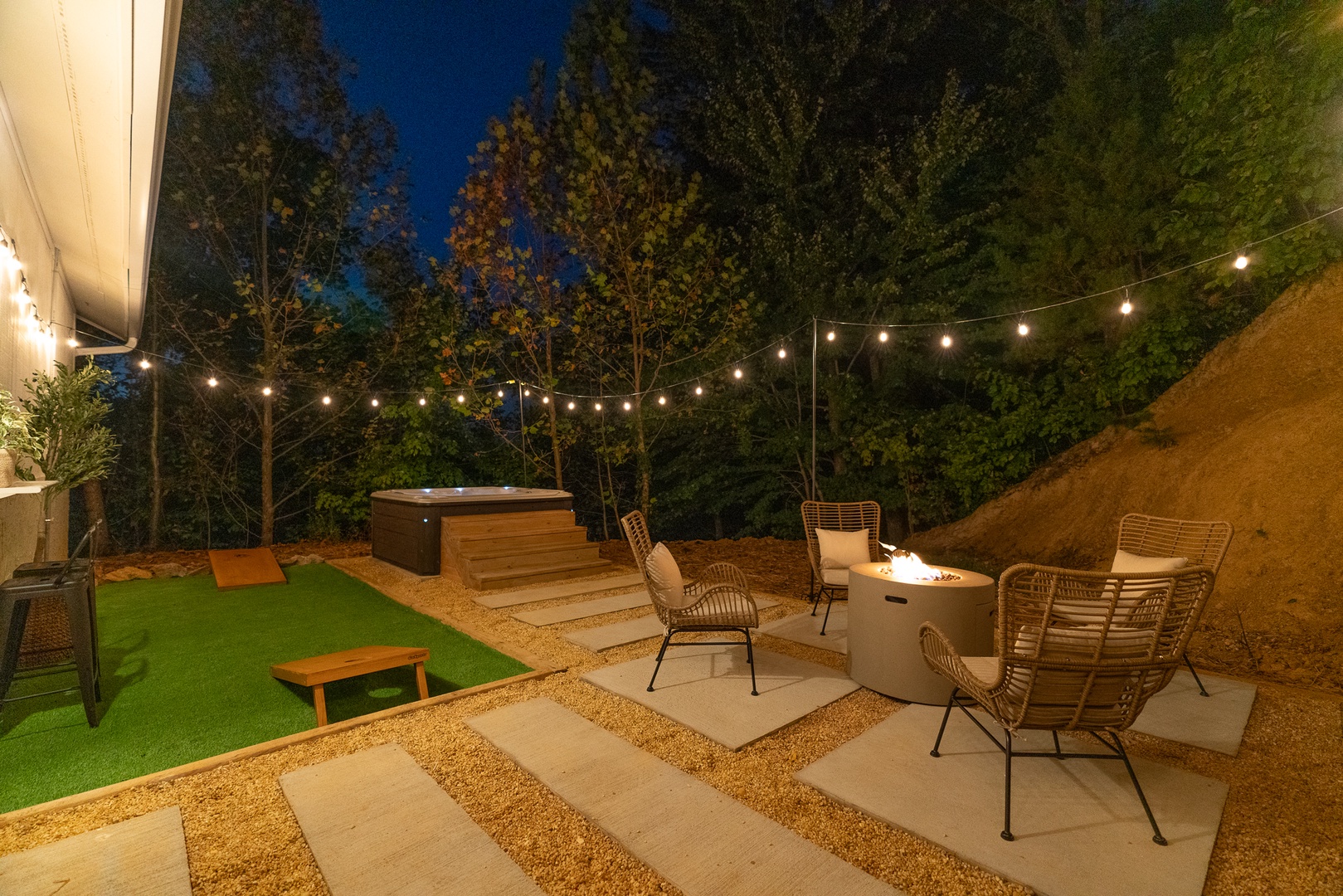 Backyard oasis with firepit, hot tub, bar seating, and cornhole for fun evenings