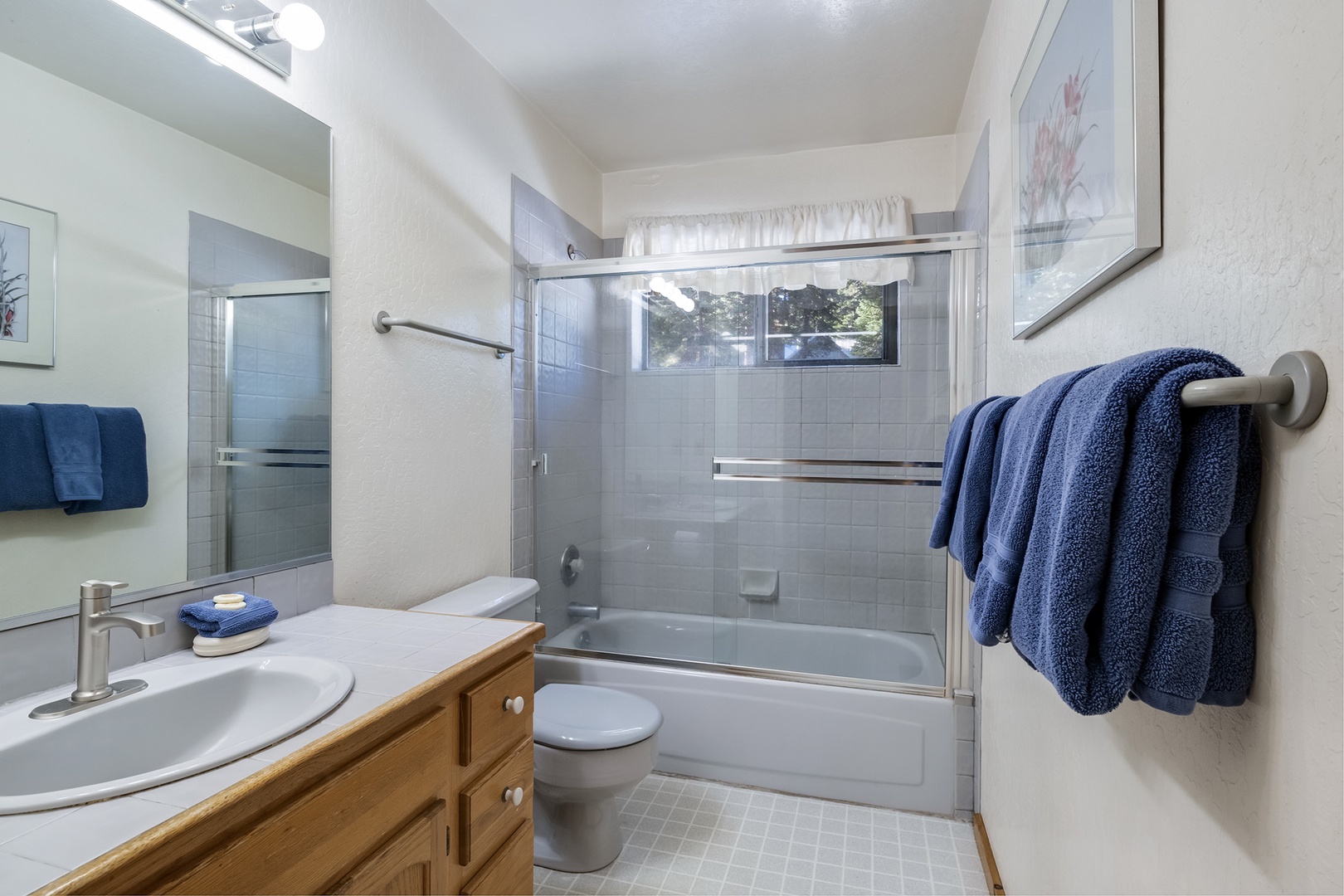 Shared bathroom with single vanity and shower/tub combo