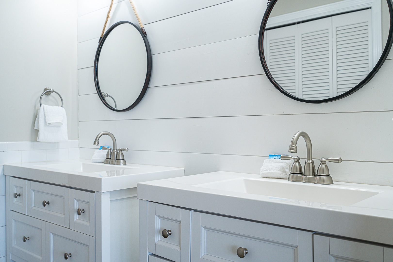 This beachy Jack & Jill bath features dual vanities & a shower/tub combo