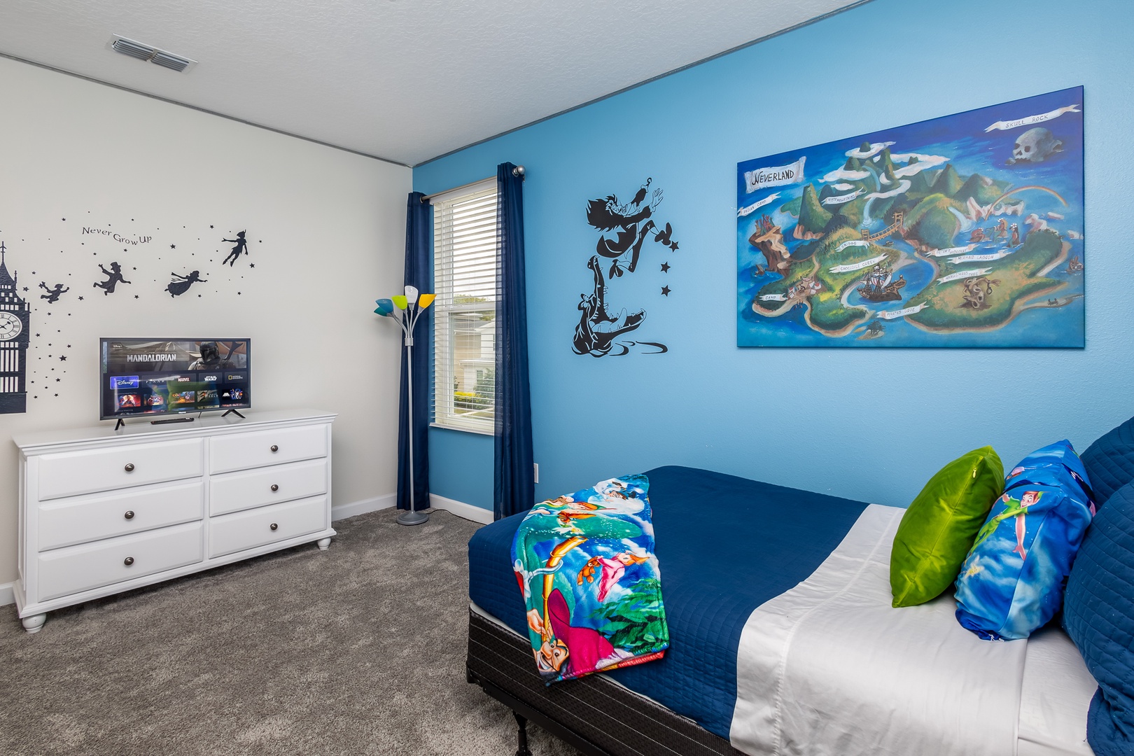 This bedroom’s twin bed, full bed, & smart TV will have you believing in fairies!