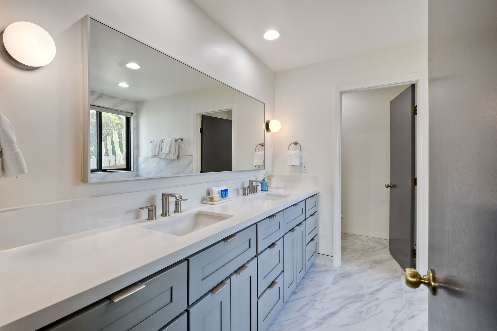 The master ensuite features a large vanity, glass shower, & luxe soaking tub