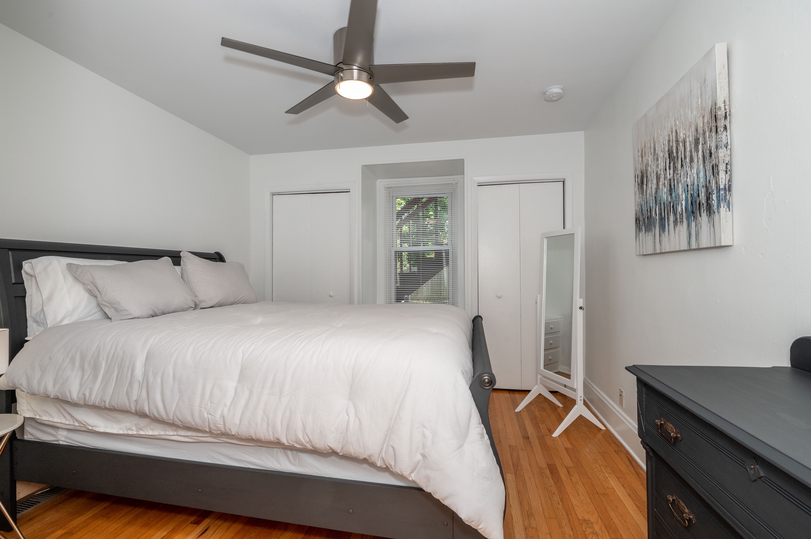 The tranquil queen bedroom includes a ceiling fan & standing mirror