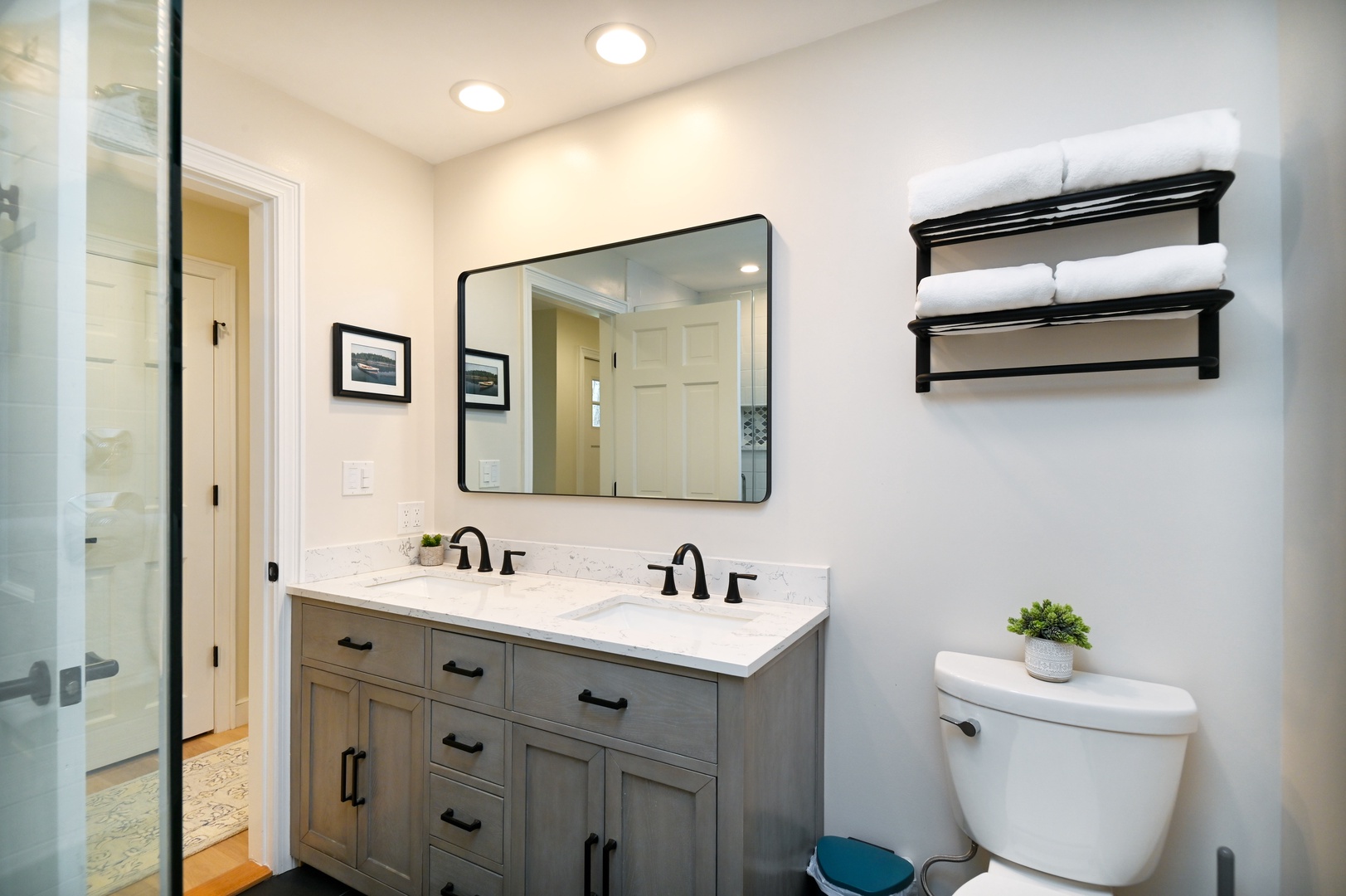 The stylish full bath showcases a double vanity & glass shower