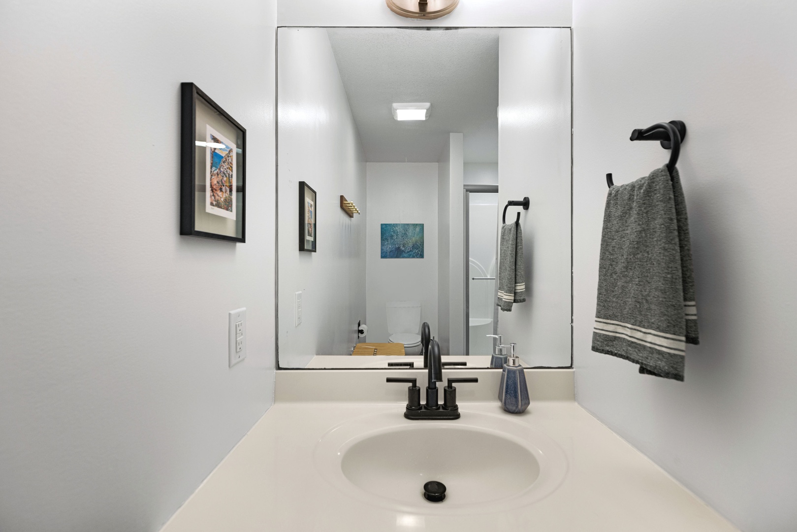 The first-floor full bath includes a single vanity, glass shower, & laundry