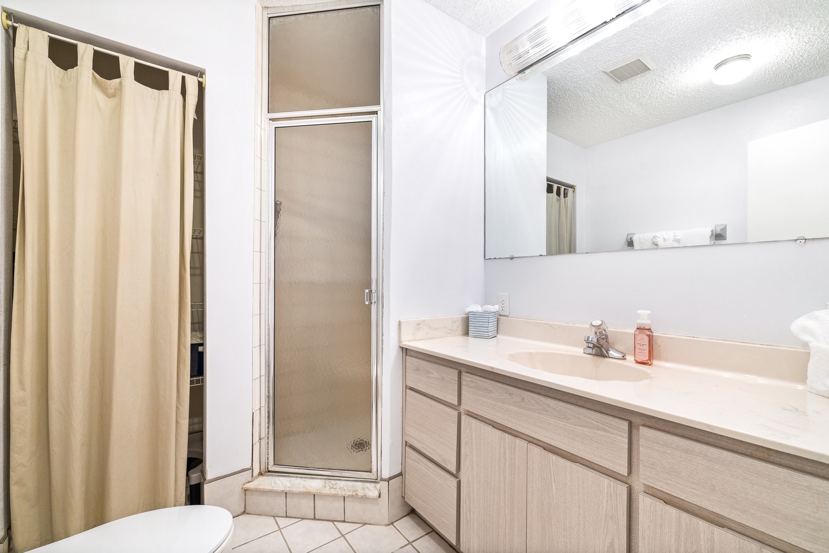 This full bathroom showcases a large single vanity & shower