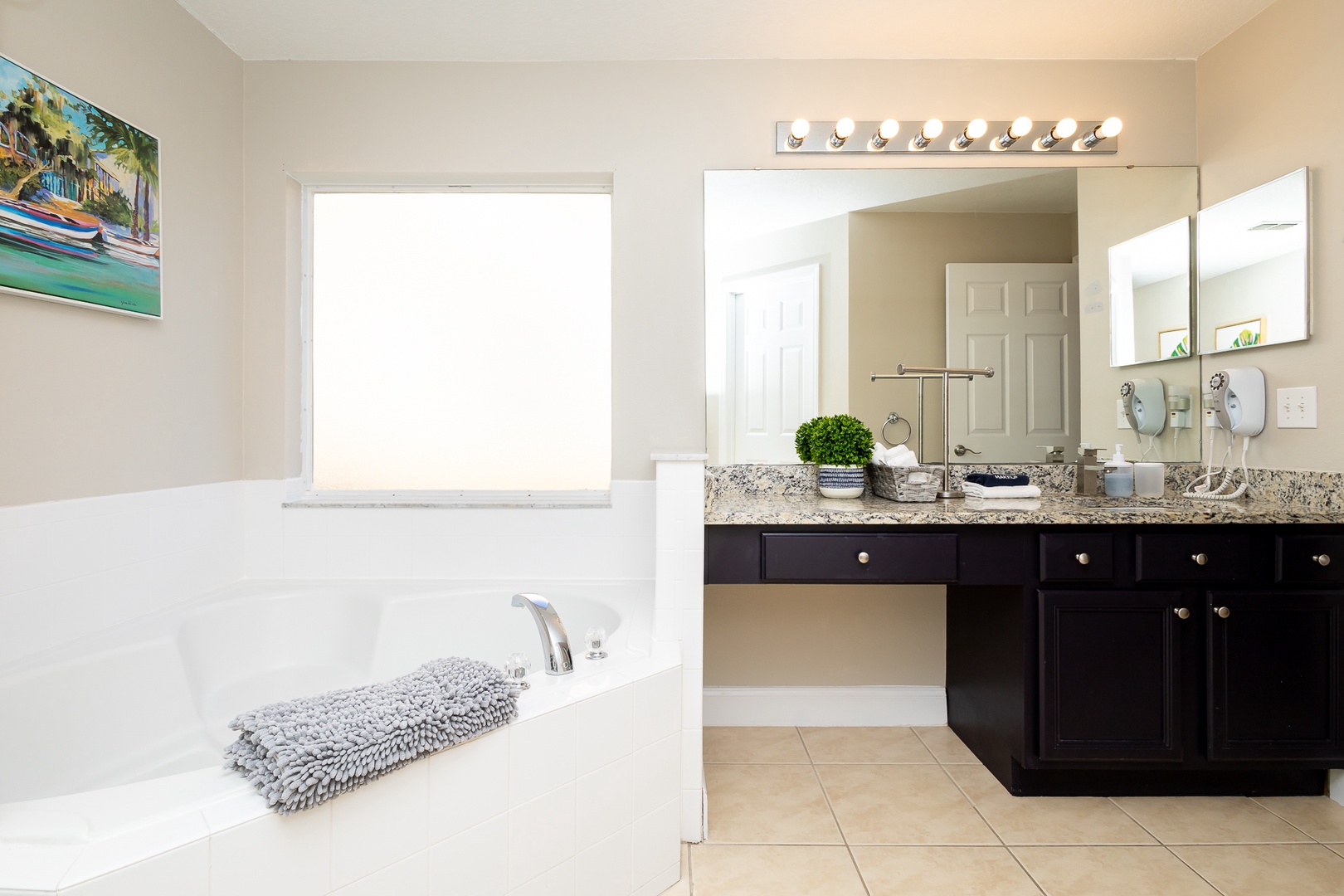 A large single vanity, shower, & soaking tub await in this main-level ensuite