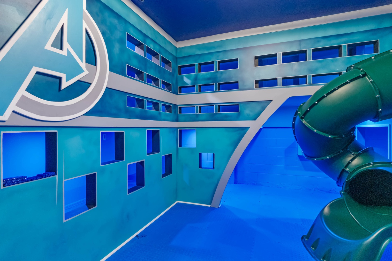Avengers garage playroom with slide, ball pit, and rock climbing wall