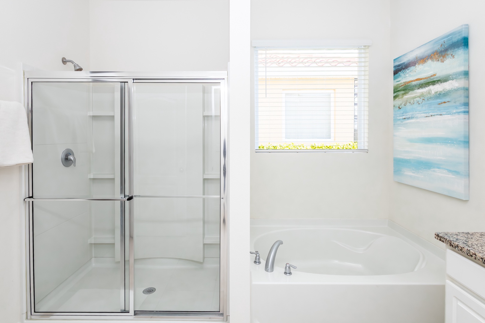 This ensuite bath features a double vanity, glass shower, and soaking tub