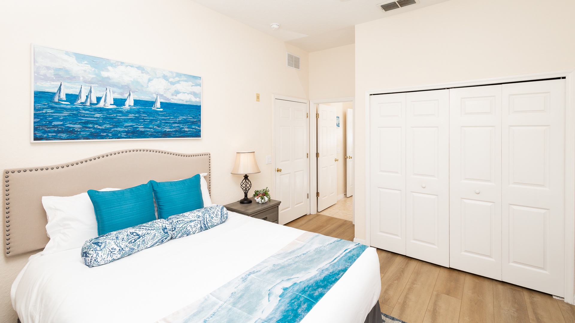 The 2nd bedroom offers a plush queen bed, balcony, Smart TV, & attached bath