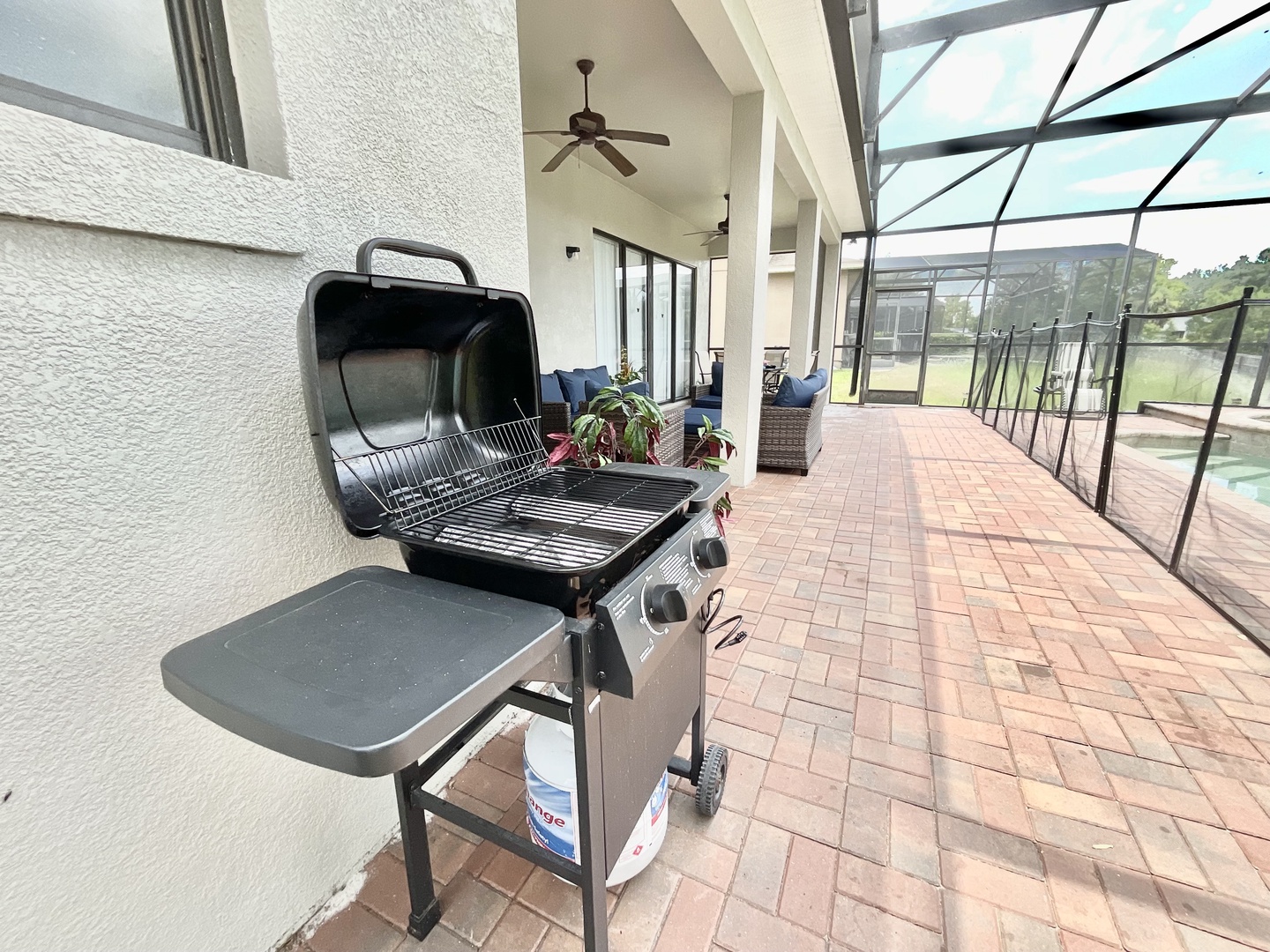 Back screened in patio with outdoor seating, grill, pool, and hot tub