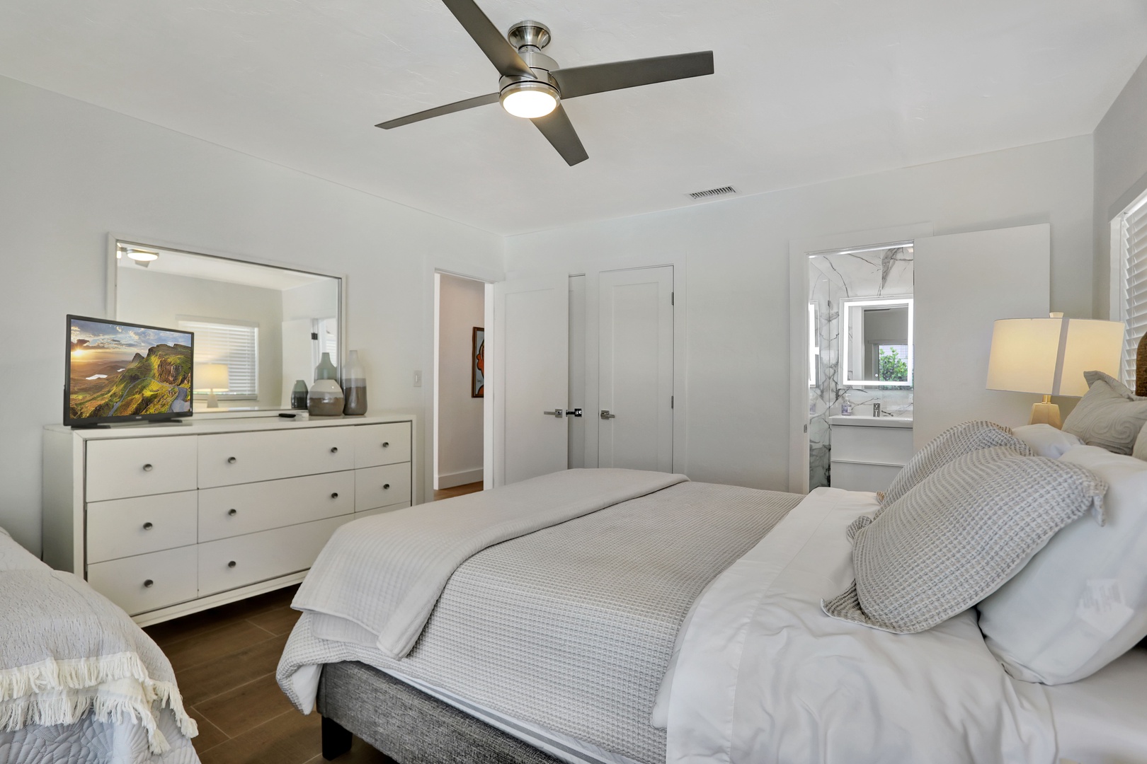 The second bedroom includes a queen bed, twin bed, ensuite, & smart TV