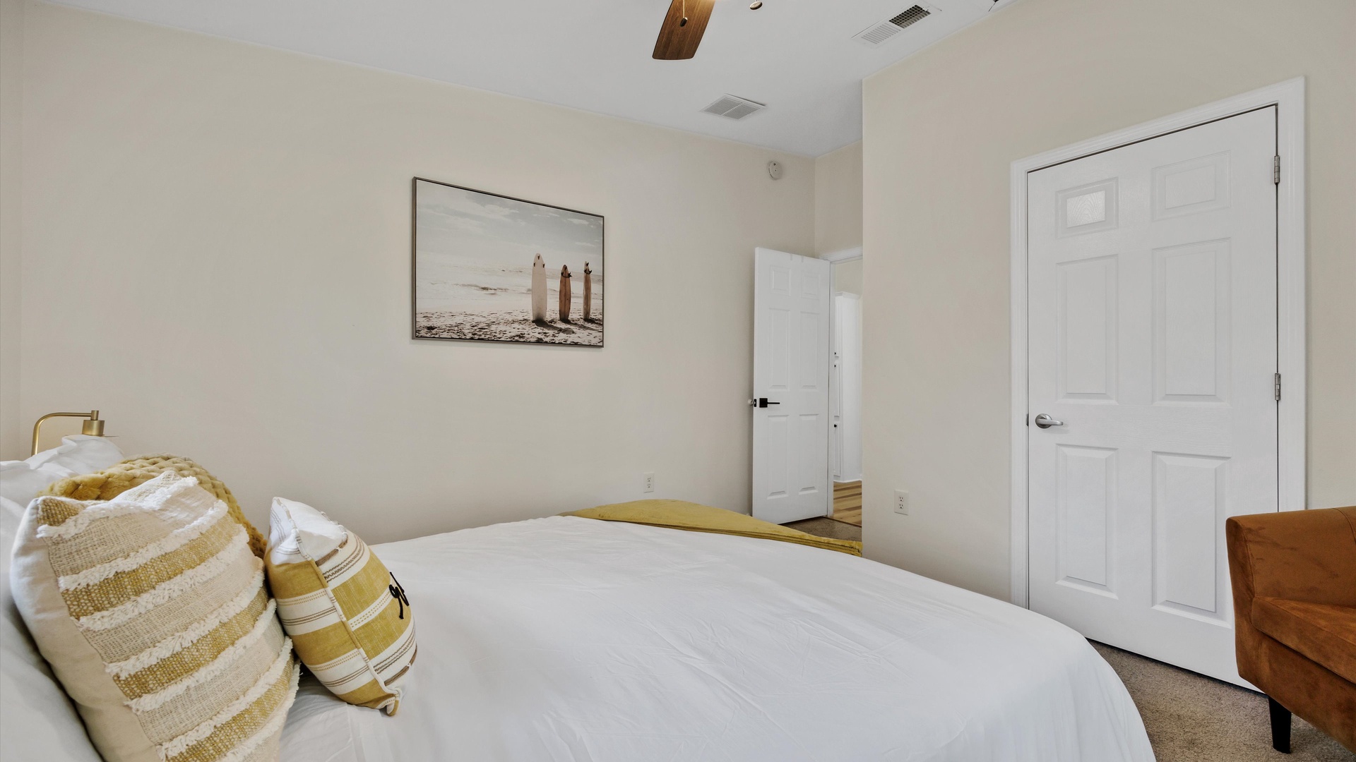 The second bedroom includes a plush queen-sized bed & lounge chair