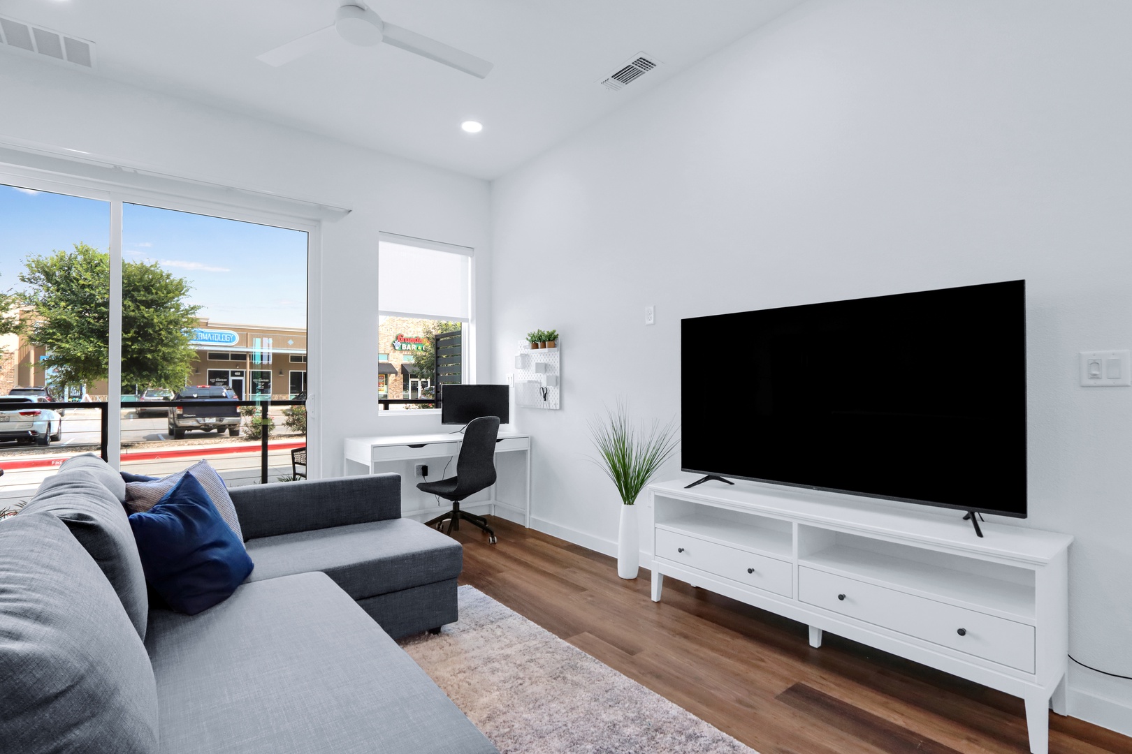 Bright living space with queen sofa sleeper, Smart TV, and workspace