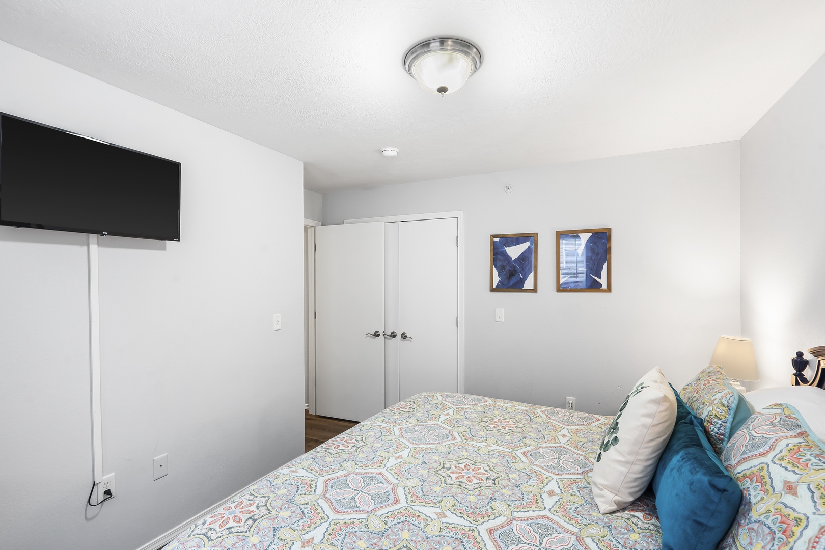 The regal third bedroom showcases a plush queen bed & Smart TV