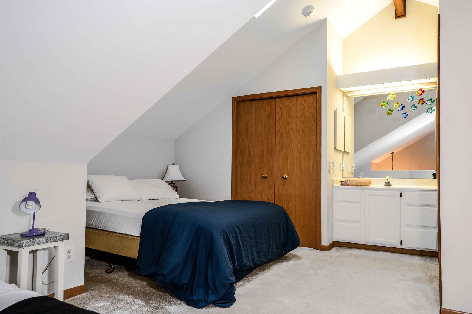 The loft contains a twin bed, queen bed & shared full bathroom
