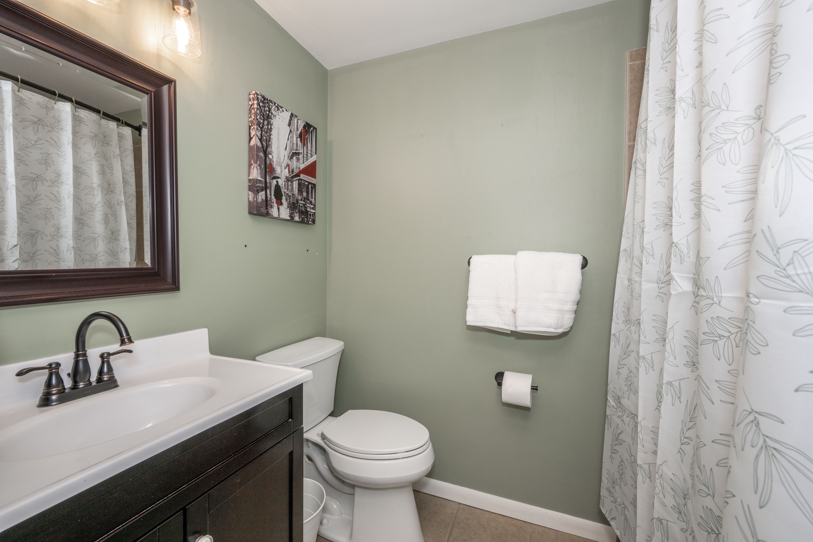 The full shared bathroom offers a single vanity & shower/tub combo