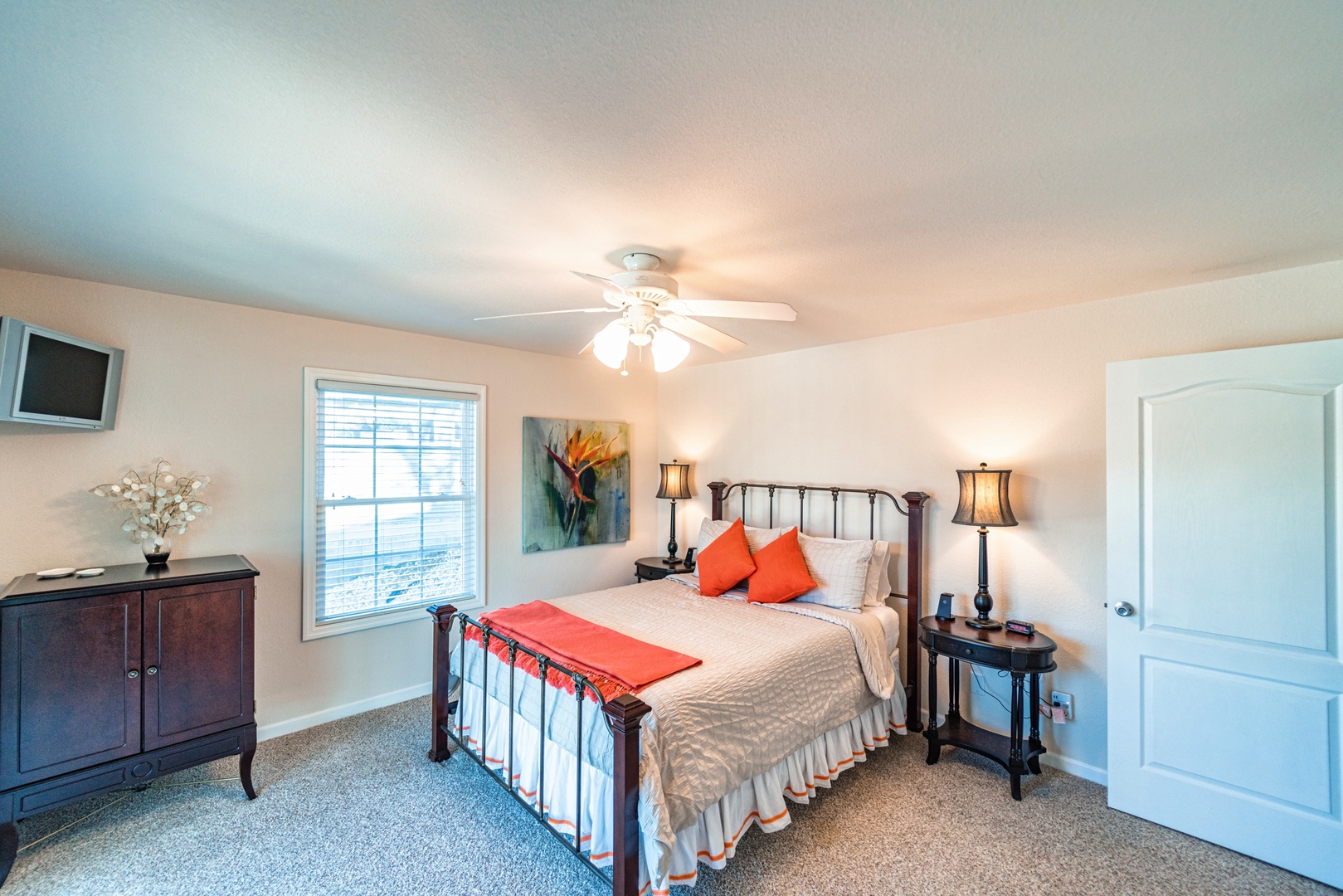 The first of 3 serene bedrooms includes a queen bed, TV, & deck access