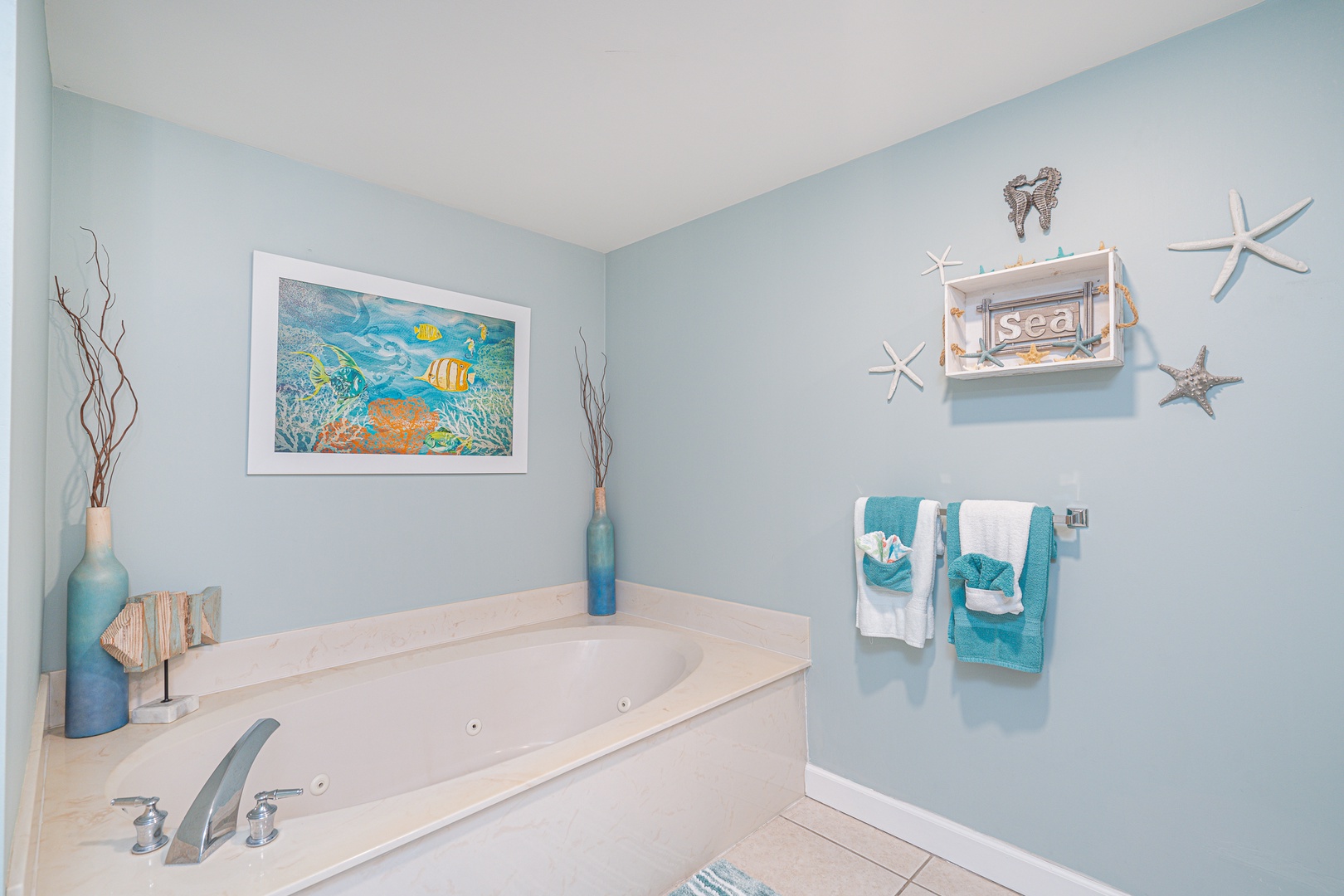 This ensuite bath features a single vanity, Jacuzzi tub, & glass shower