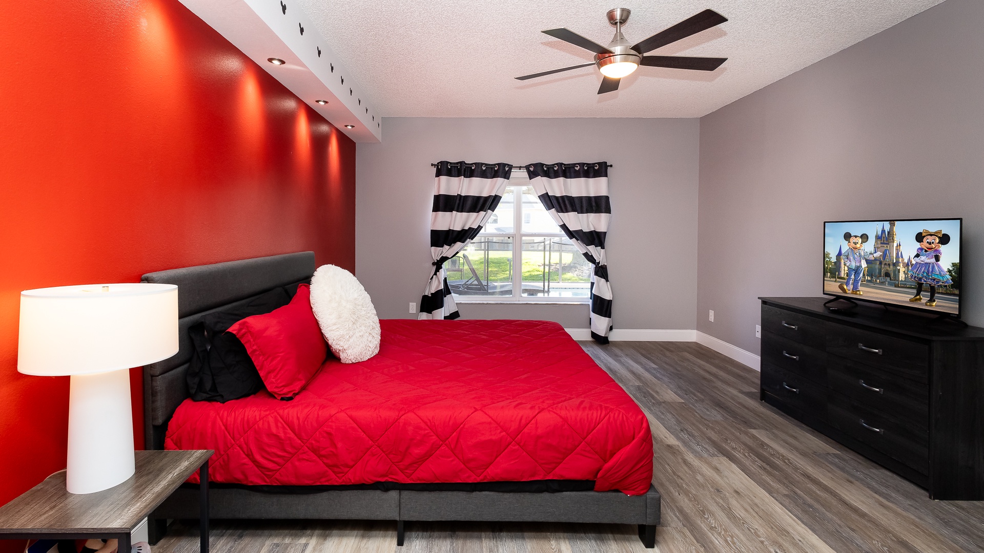 Mickey-themed bedroom with king bed, smart TV, and ensuite bath for a magical stay