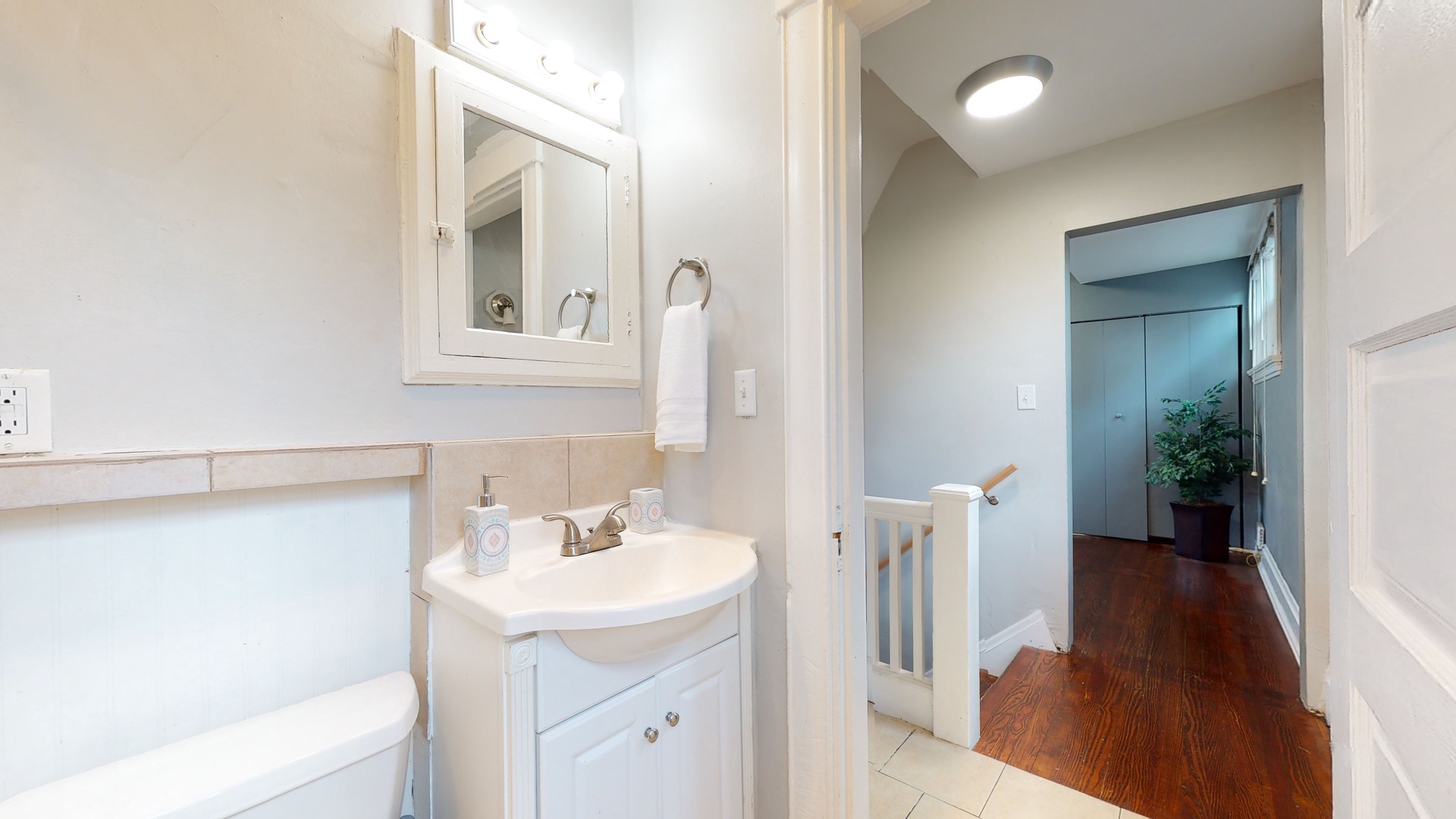 The full bath features a single vanity, mirror storage, & shower/tub combo