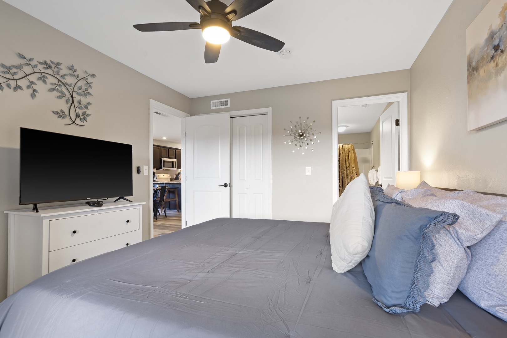 The serene primary suite boasts a king-sized bed, ensuite, TV, & deck access