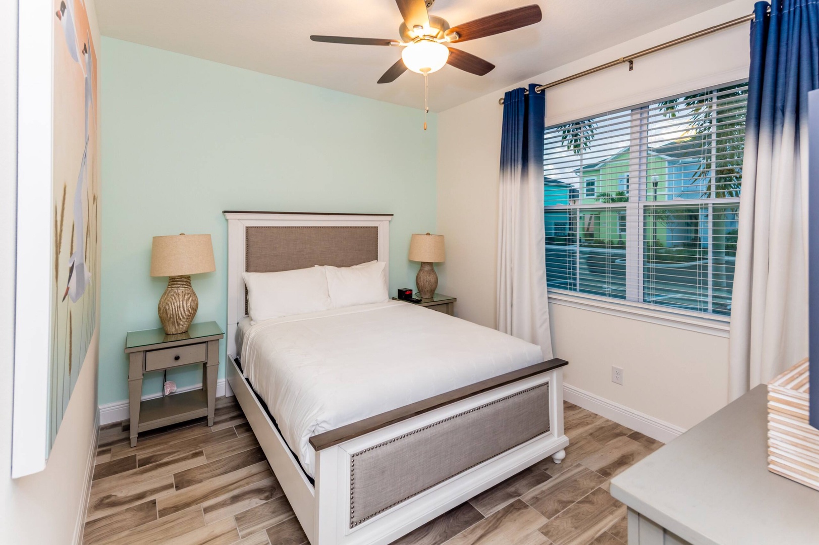 The beachy 2nd floor queen bedroom includes a smart TV & ceiling fan