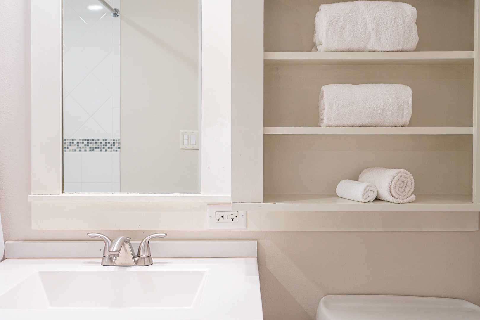 The airy full bathroom features a single vanity & shower/tub combo