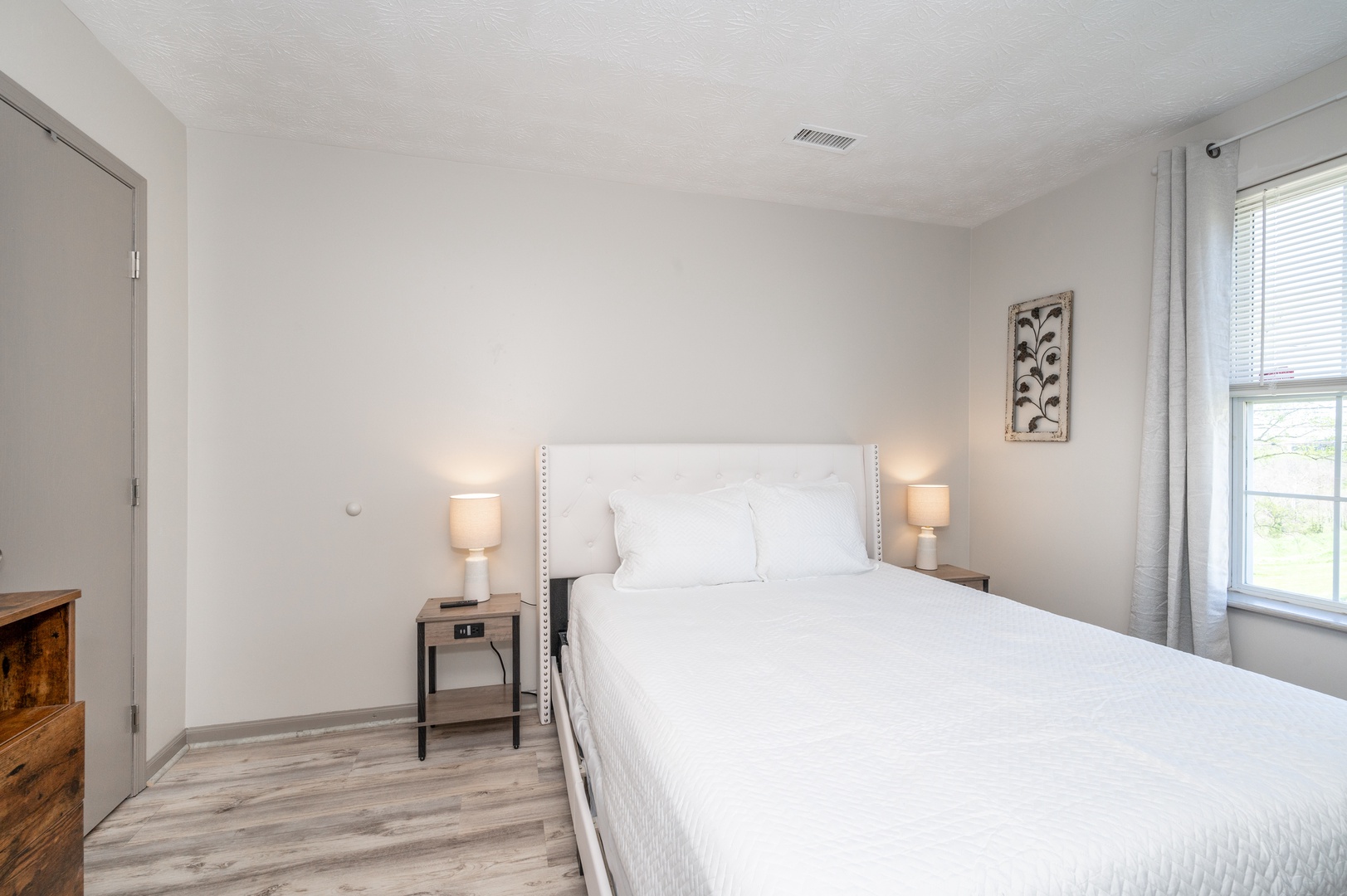 The first of two spacious bedrooms boasts a plush queen bed & Smart TV