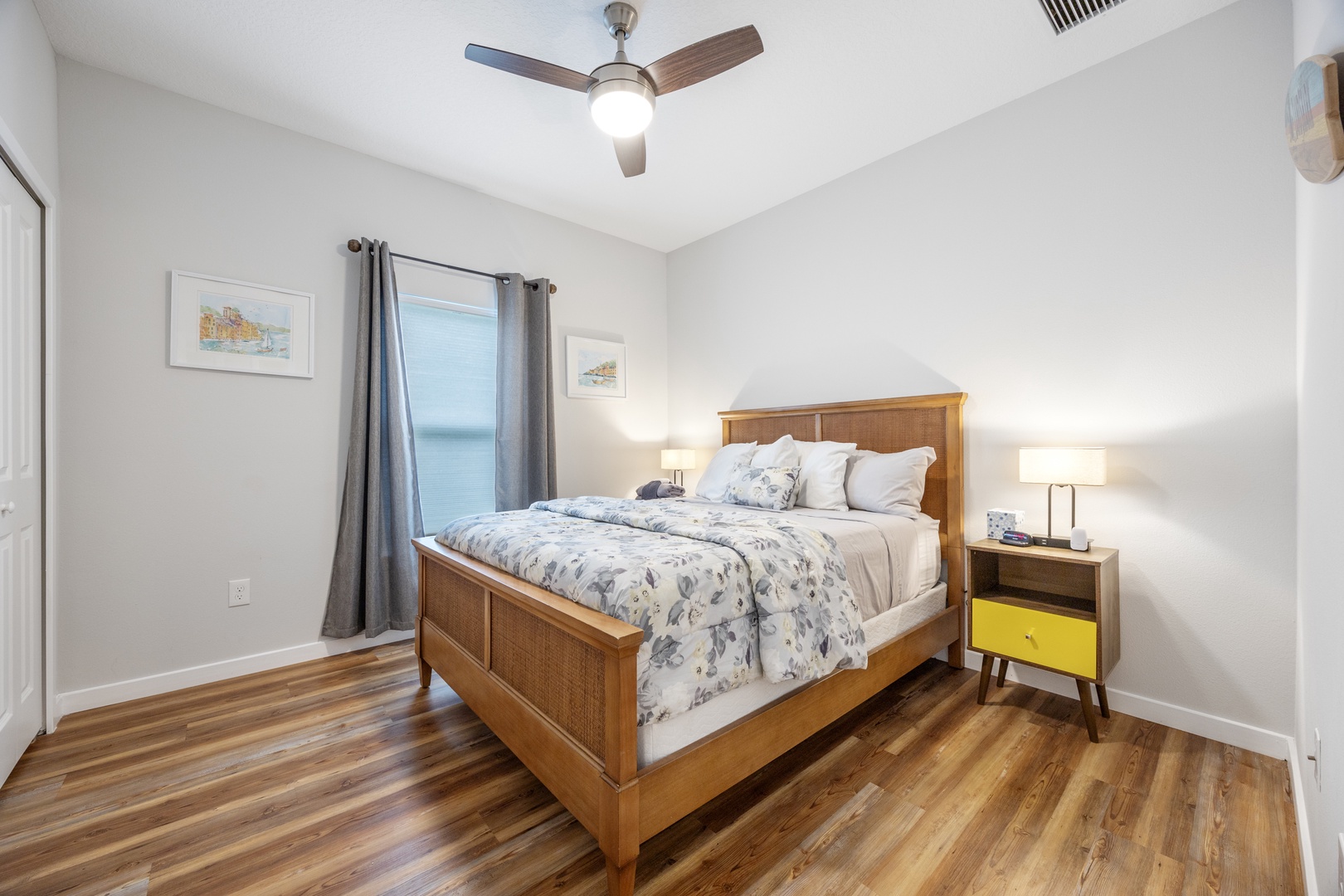 This bedroom features a plush queen-sized bed, with ceiling fan