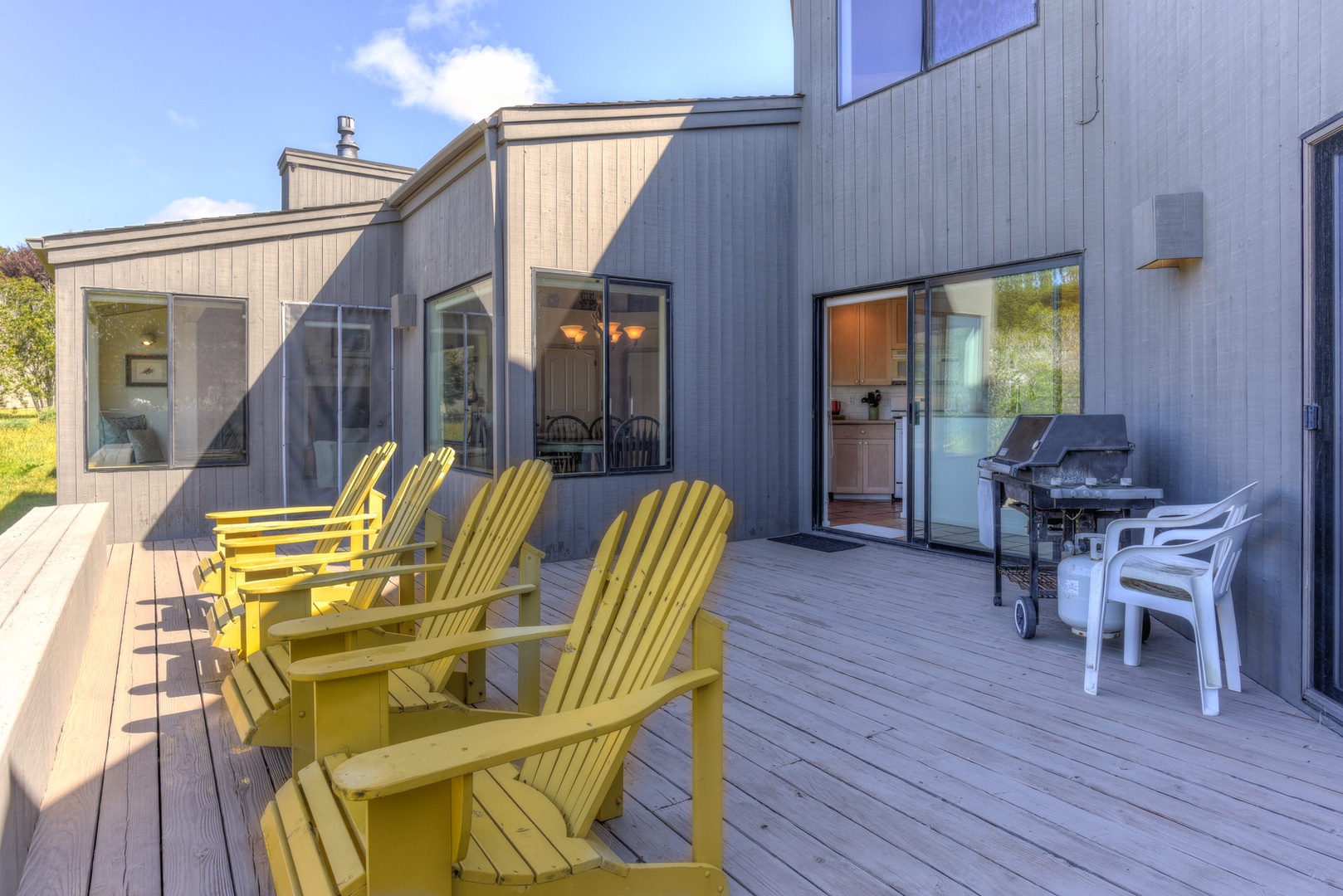 Large back deck with partial ocean view and outdoor seating , and BBQ