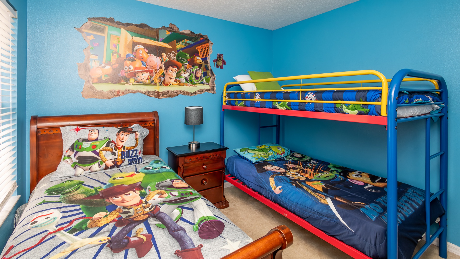 Toy Story-themed bedroom with a twin bunk bed and an extra twin bed