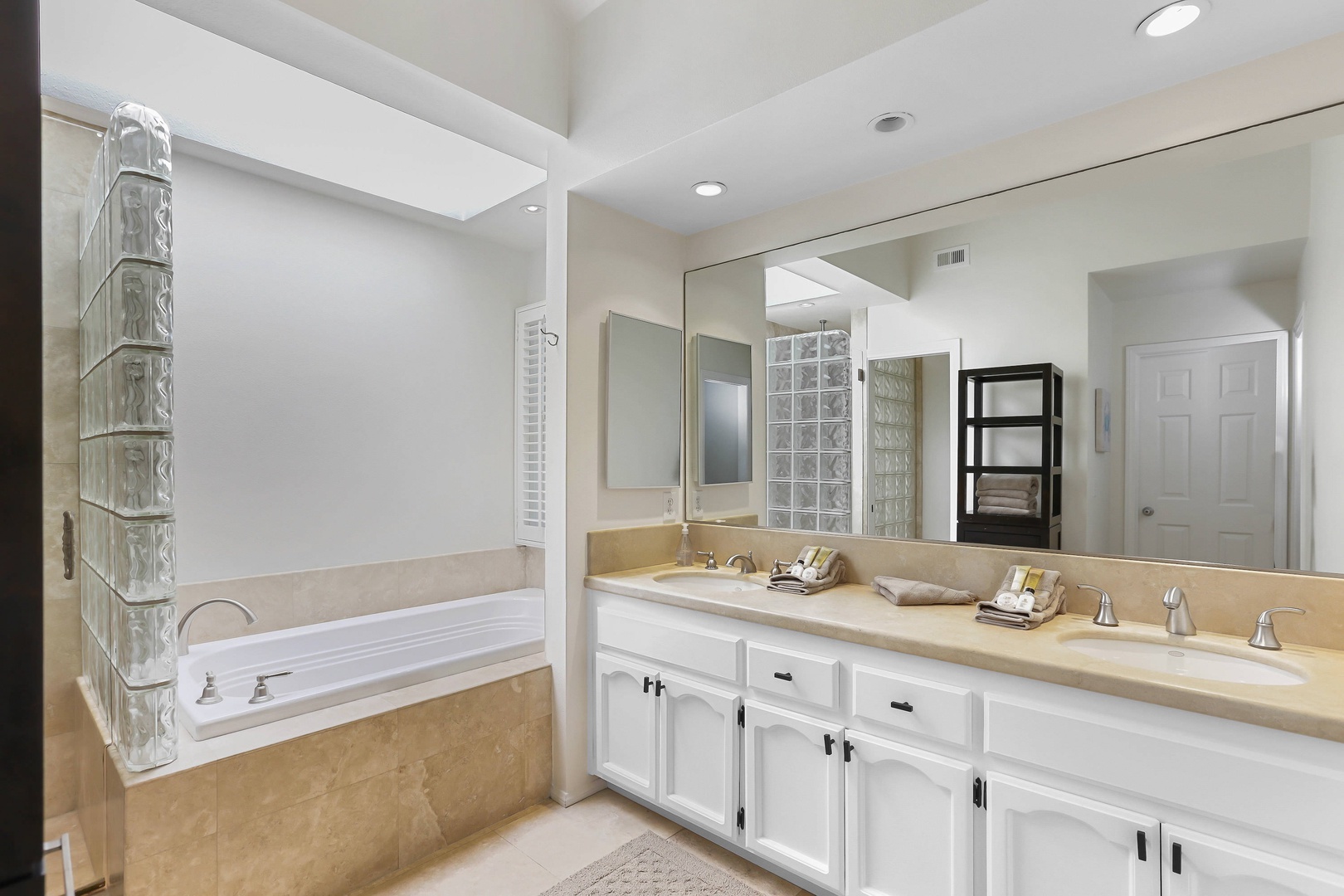 En suite bathroom with dual sinks, soaking tub and standing shower