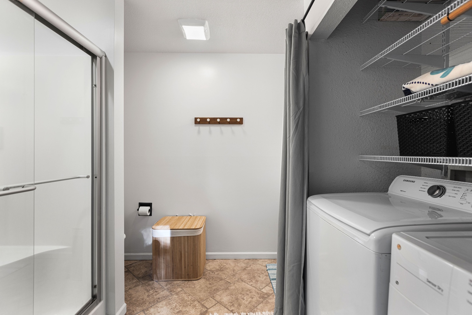 The first-floor full bath includes a single vanity, glass shower, & laundry