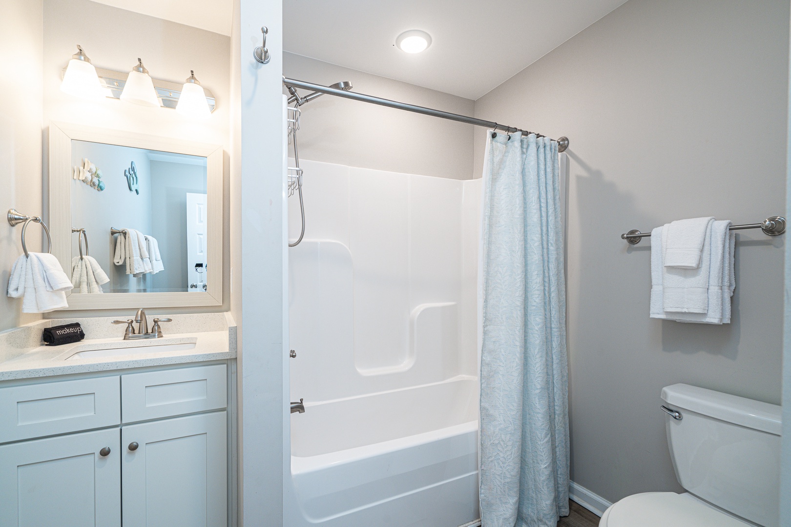 This shared full bathroom offers a single vanity & shower/tub combo