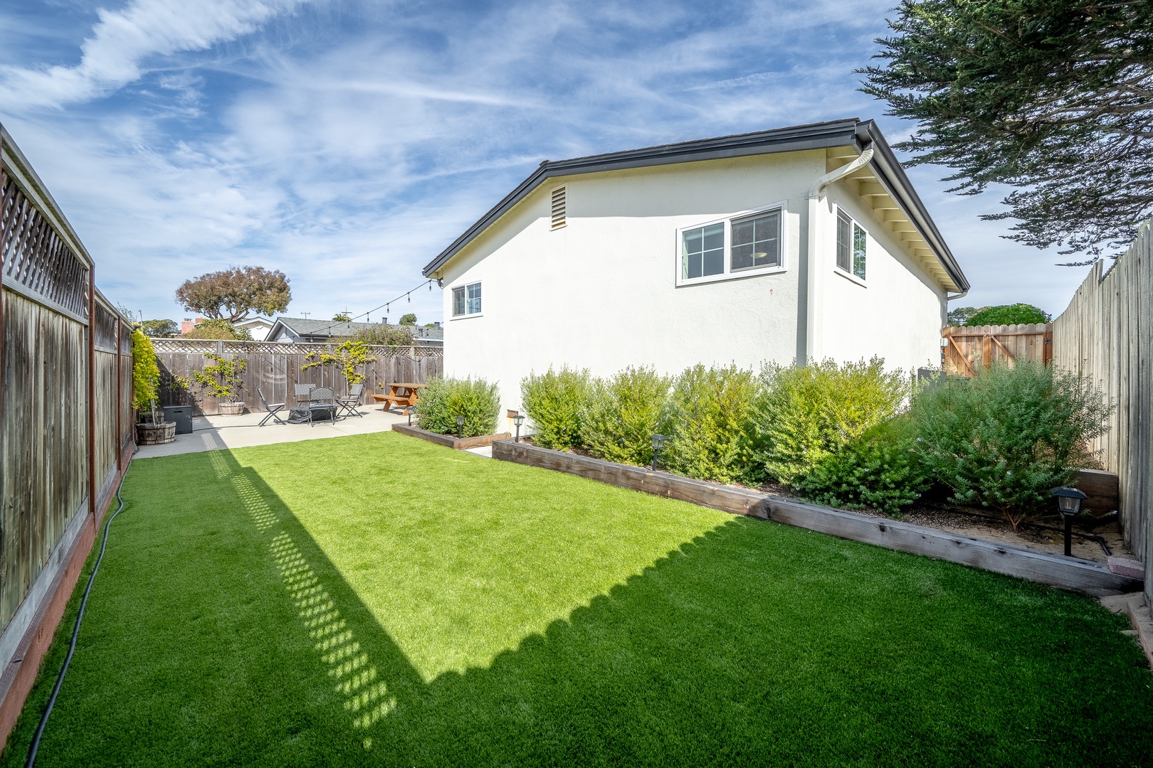 The private back yard offers ample space for relaxation, dining, & play