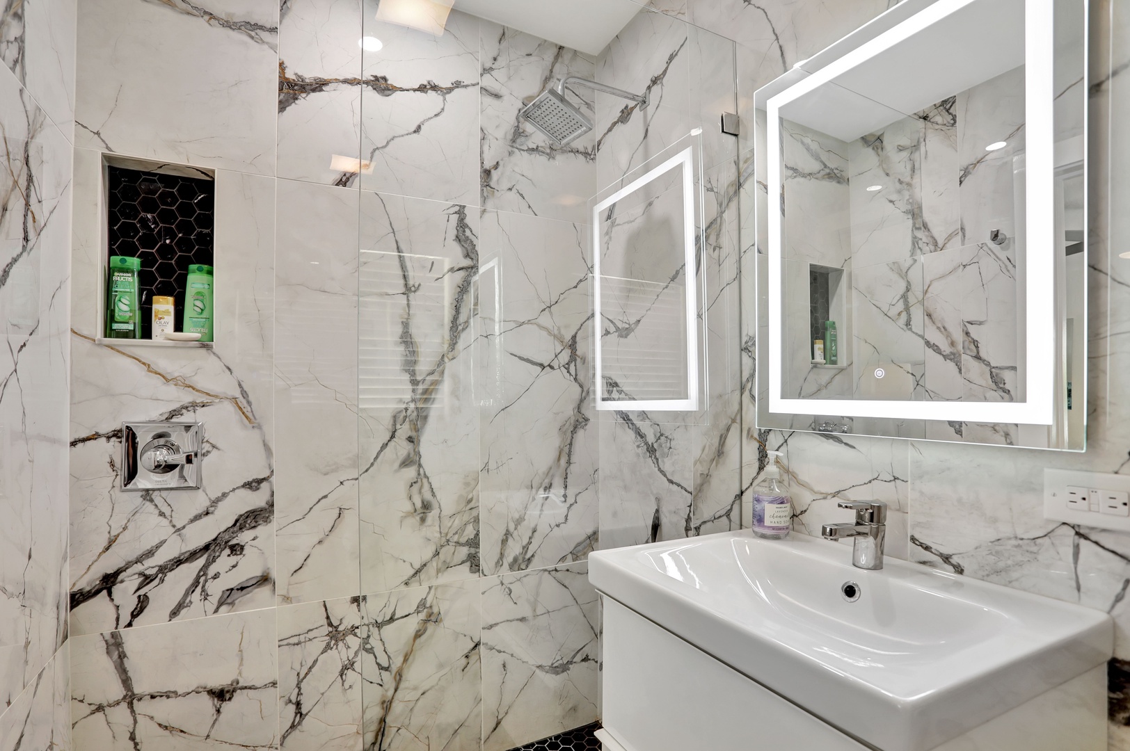 This queen ensuite features a sleek single vanity & glass shower