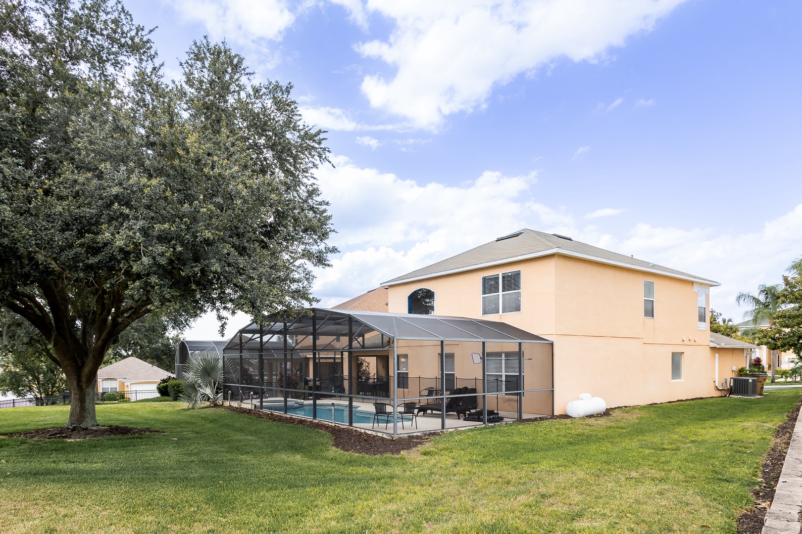 Orlando retreat: pool, hot tub, and lounge chairs under a serene lanai