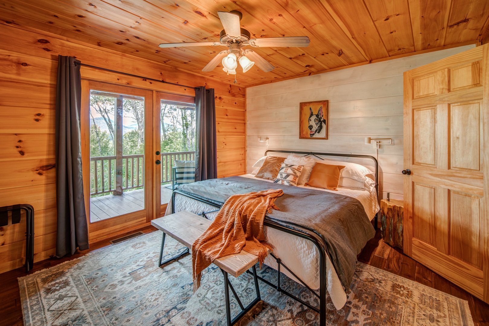 This main-level bedroom offers a king bed & access to the wraparound deck