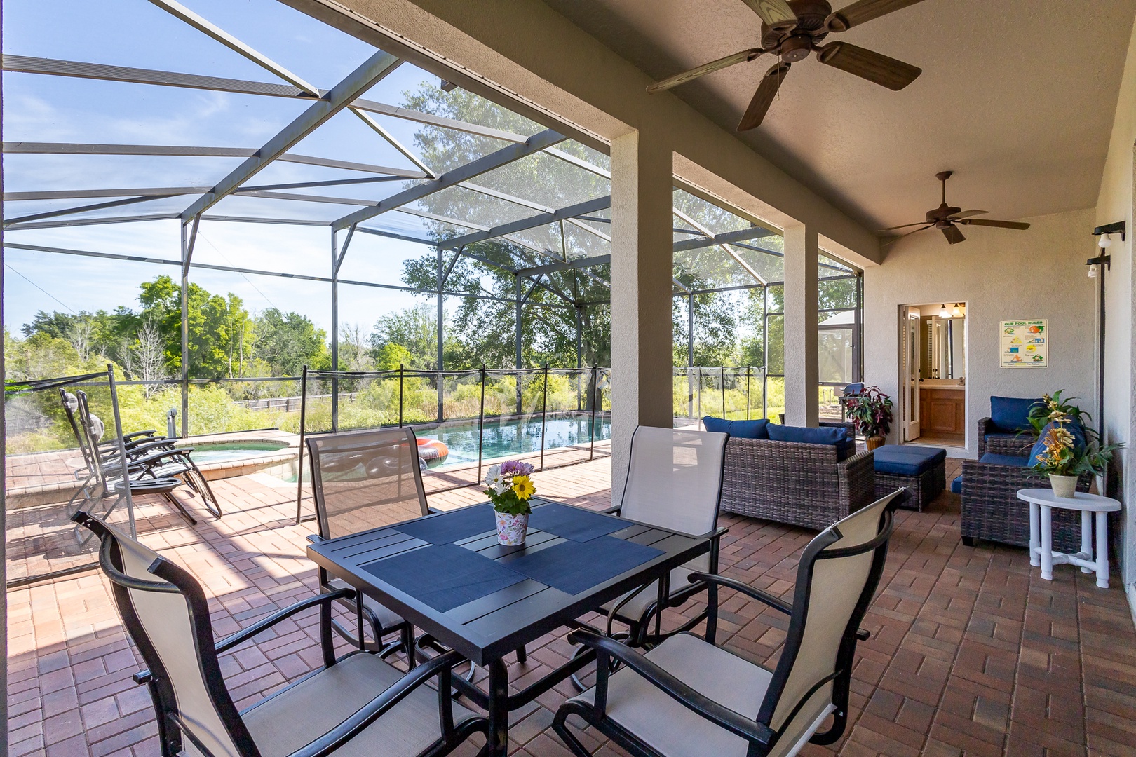 Back screened in patio with outdoor seating, grill, pool, and hot tub