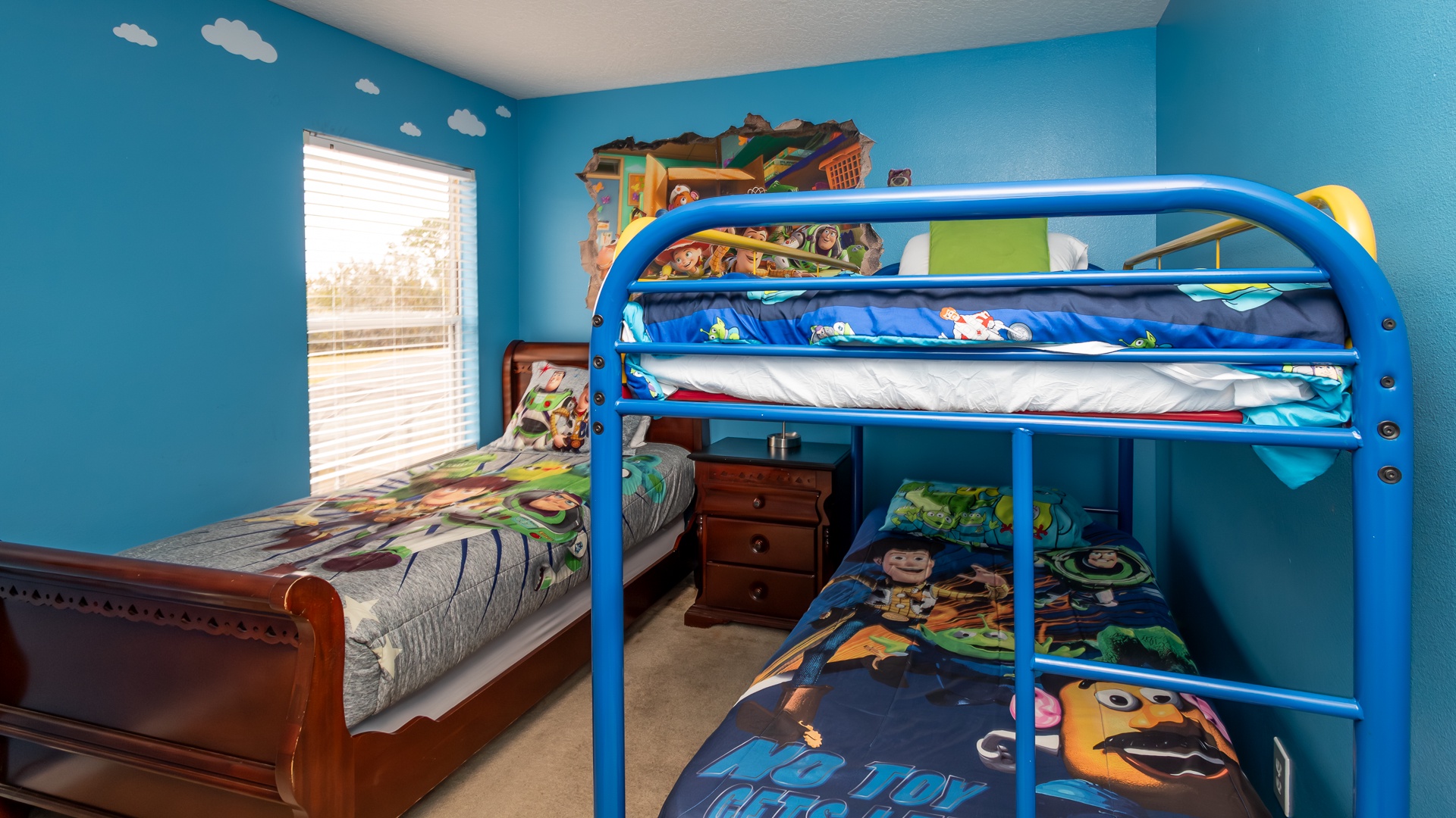 Toy Story-themed bedroom with a twin bunk bed and an extra twin bed