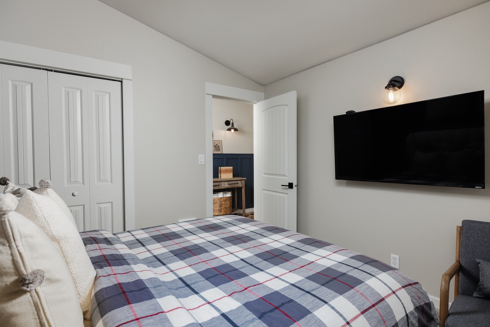 The first of two bedrooms, offering a plush queen bed & Smart TV
