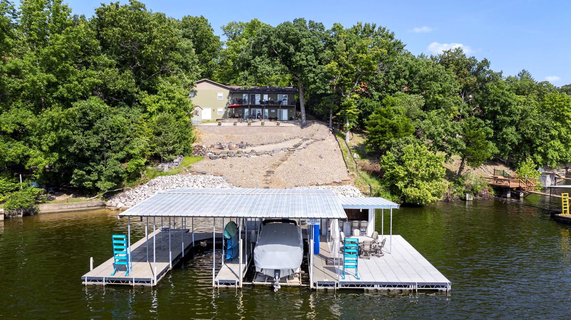 Experience the ultimate dock with BBQ, bar, ample seating, 2 kayaks, a water mat, and a convenient 10x28 boat slip