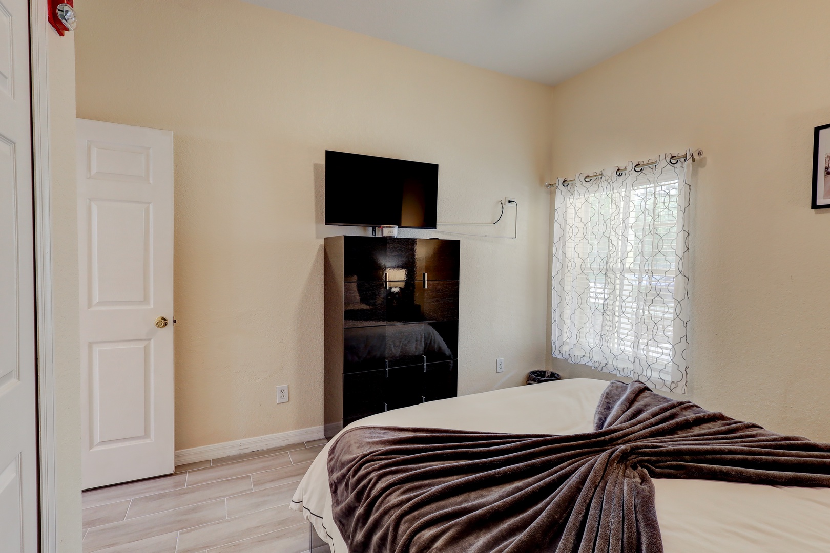 This chic queen bedroom includes a Smart TV & large dresser