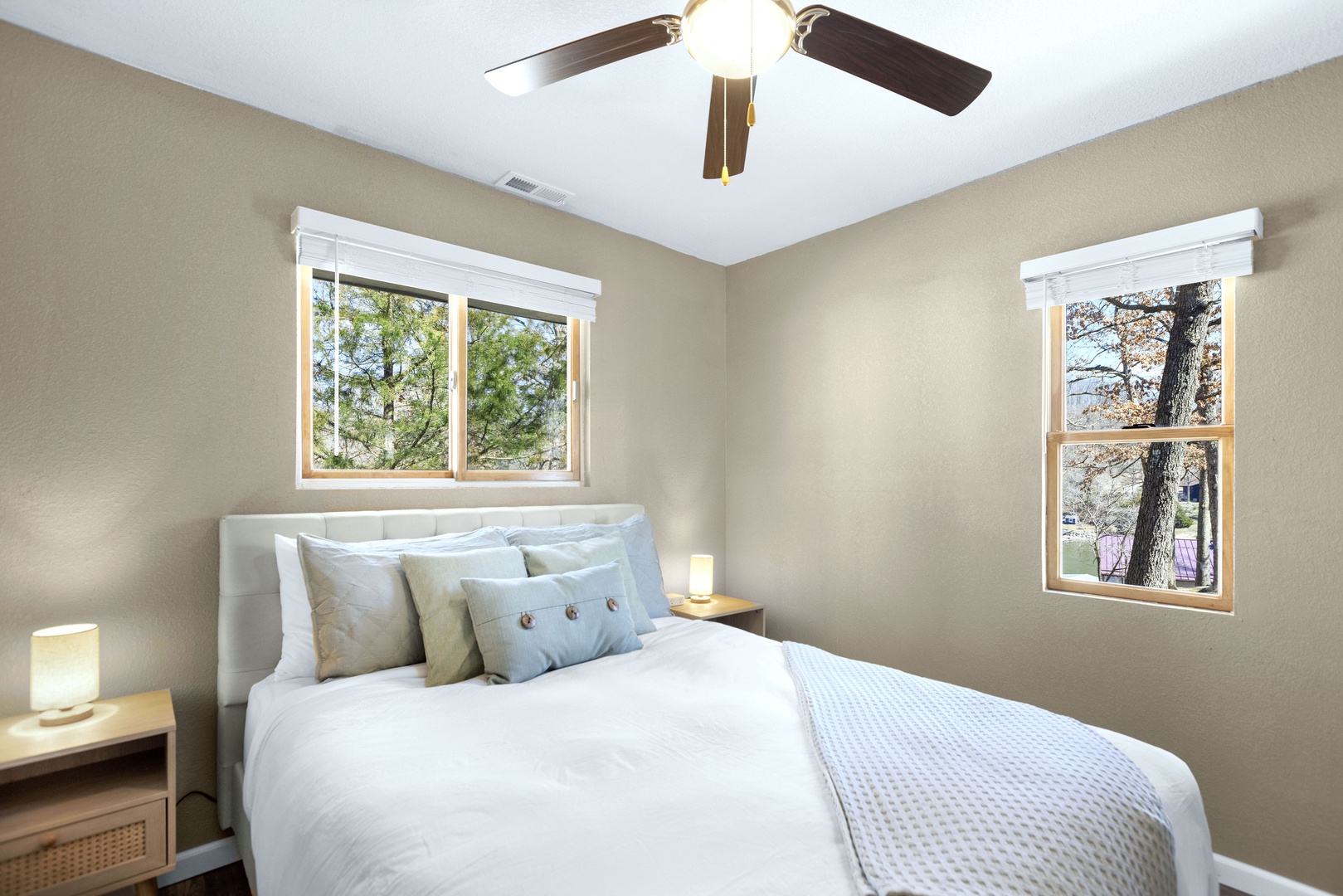This serene bedroom includes a queen-sized bed & ceiling fan