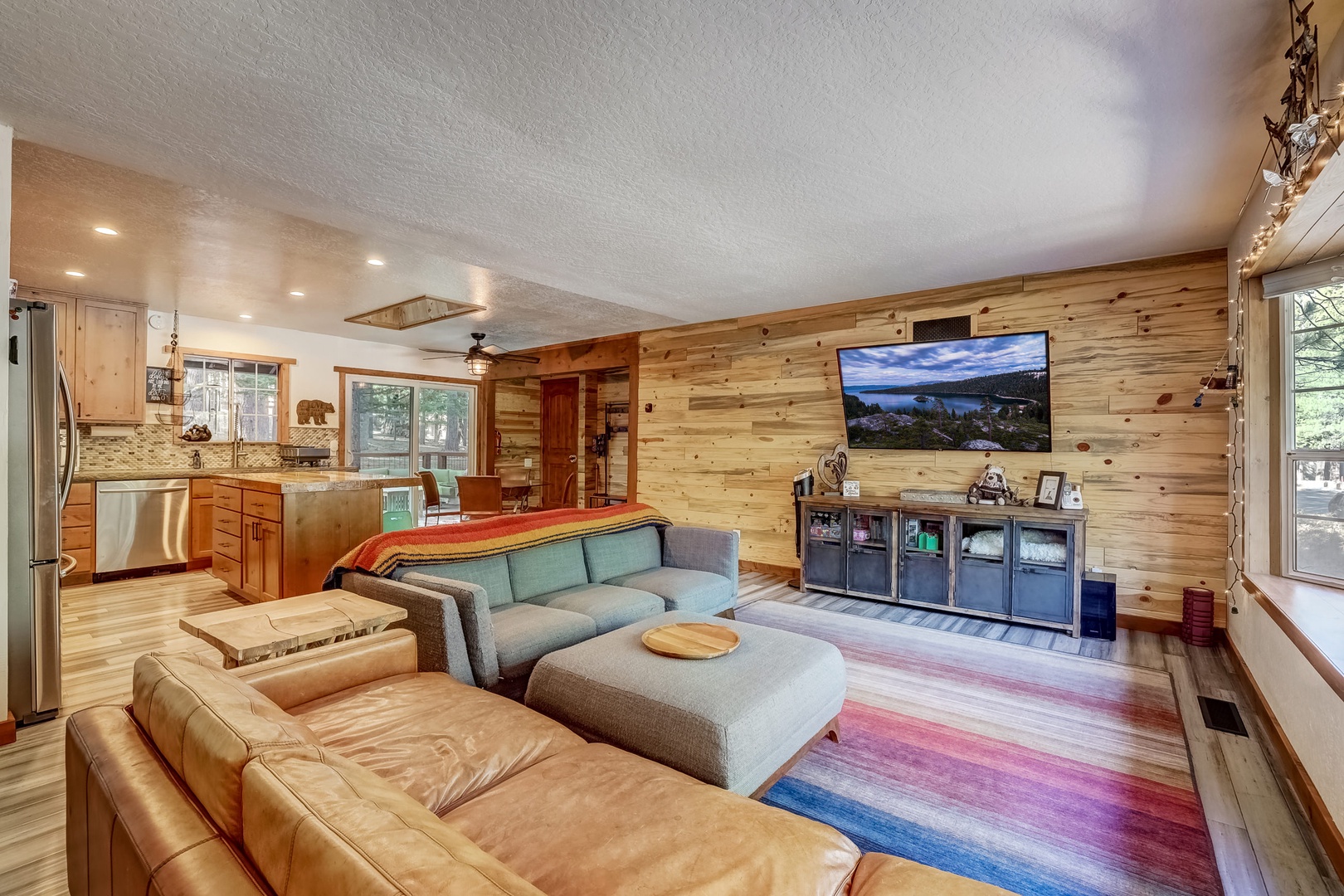 Open living space with oversized sofa, large wood burning stove, and TV