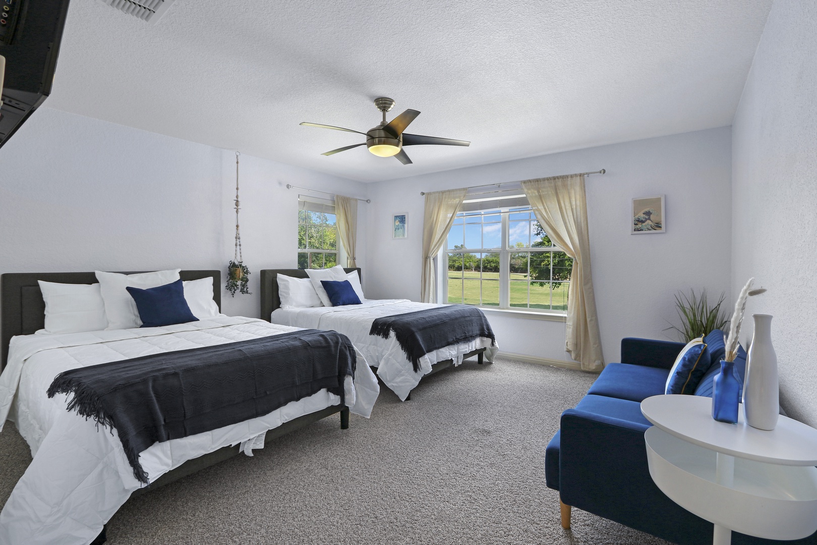 Bedroom 4 offers 2 chic queen beds, Smart TV, & a comfy lounge couch